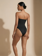 Back angled view of black strapless thong shaper with smooth thong design and waist shaping