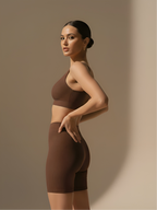 Side view of brown bra and pant set with high waist shorts and stretch support